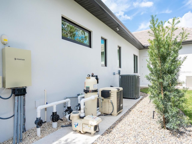 view of side of home with a tiled roof, cooling unit, and stucco siding