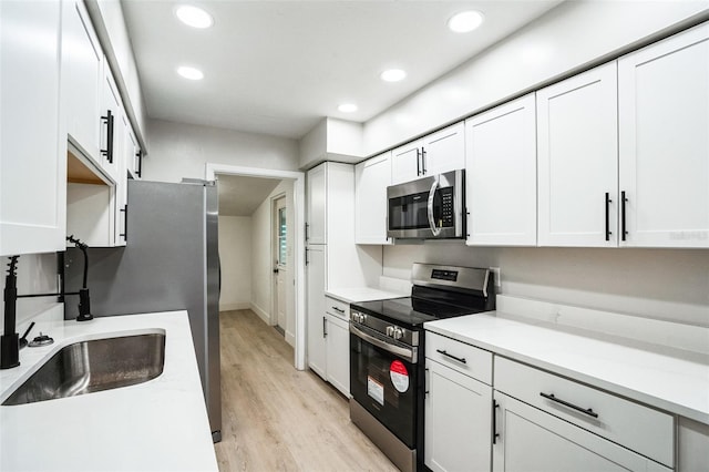 kitchen featuring light countertops, appliances with stainless steel finishes, and white cabinetry