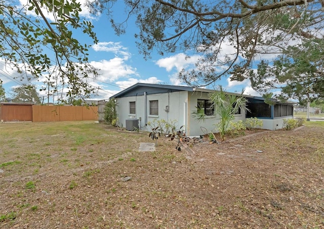 rear view of house featuring a yard, cooling unit, and fence