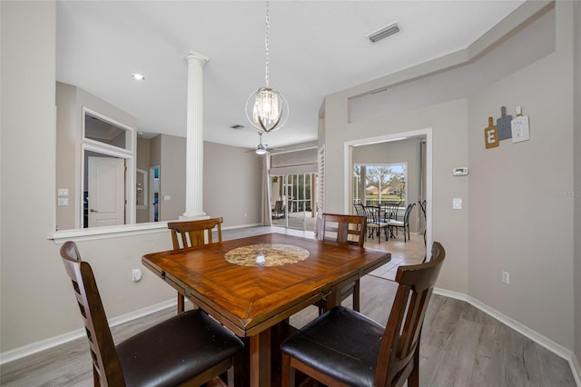 dining space with visible vents, baseboards, a ceiling fan, light wood finished floors, and decorative columns