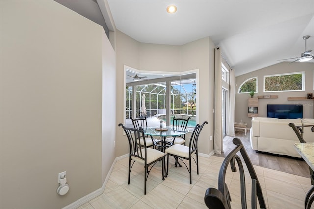 dining space featuring lofted ceiling, a sunroom, baseboards, and a ceiling fan