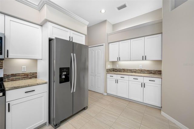 kitchen with tasteful backsplash, visible vents, white cabinets, stainless steel fridge with ice dispenser, and light stone countertops