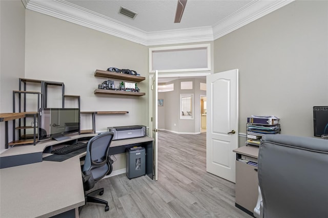 office with baseboards, visible vents, ceiling fan, crown molding, and light wood-type flooring