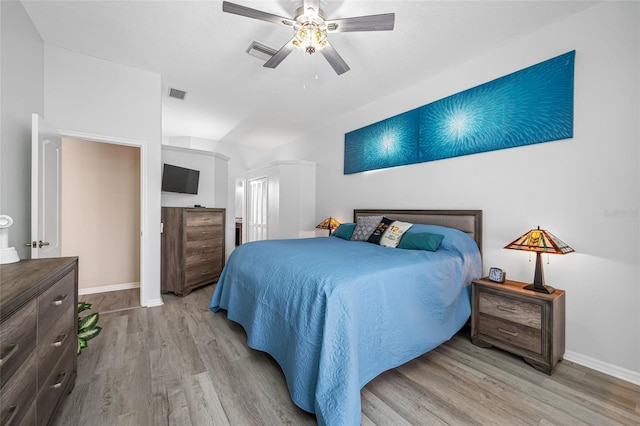 bedroom featuring light wood-style floors, visible vents, ceiling fan, and baseboards