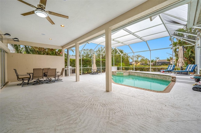 view of swimming pool with a pool with connected hot tub, a patio area, glass enclosure, ceiling fan, and outdoor dining area