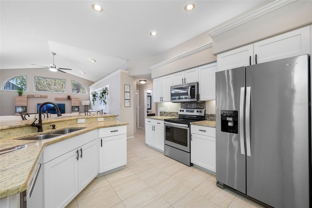 kitchen featuring a sink, stainless steel appliances, light tile patterned flooring, vaulted ceiling, and ceiling fan
