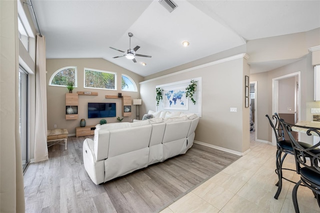 living room featuring lofted ceiling, a ceiling fan, baseboards, light wood finished floors, and visible vents