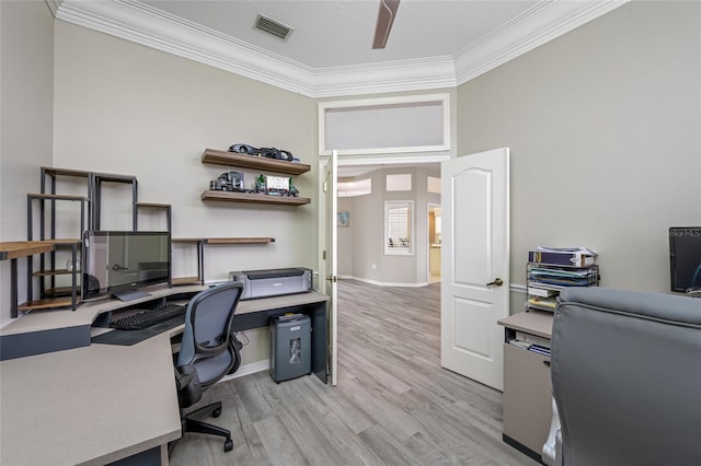 home office with baseboards, ornamental molding, light wood finished floors, ceiling fan, and visible vents