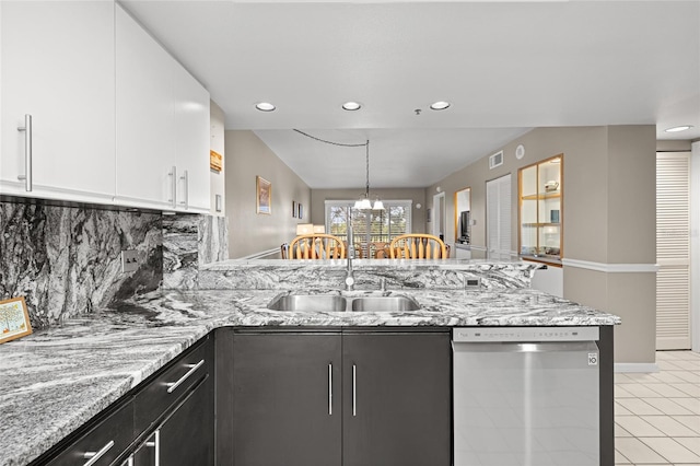 kitchen featuring white cabinetry, a peninsula, a sink, stainless steel dishwasher, and tasteful backsplash