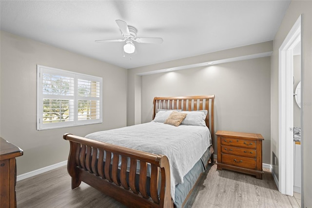 bedroom featuring a ceiling fan, wood finished floors, and baseboards