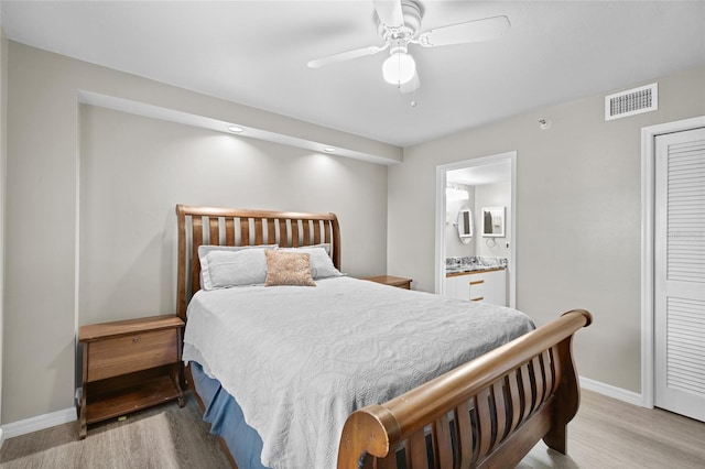 bedroom featuring visible vents, light wood-type flooring, ensuite bathroom, and baseboards