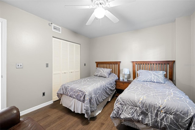 bedroom with visible vents, baseboards, dark wood finished floors, ceiling fan, and a closet