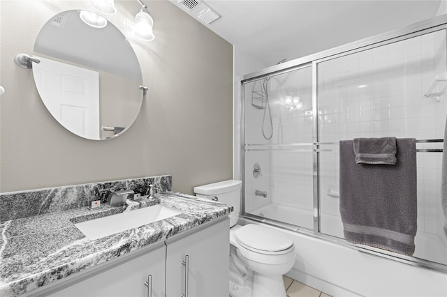 bathroom with visible vents, toilet, vanity, and bath / shower combo with glass door