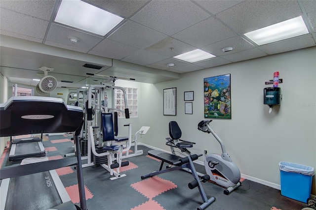 gym with baseboards and a drop ceiling