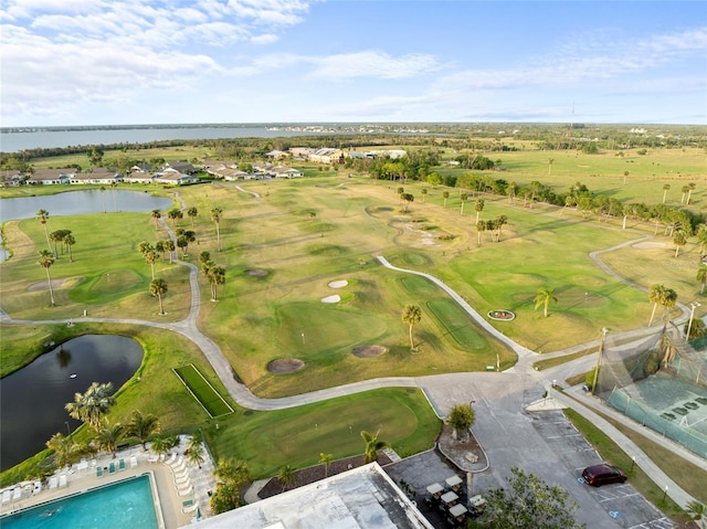 birds eye view of property with golf course view and a water view