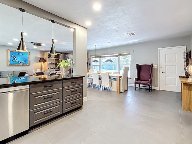 kitchen featuring dark countertops, gray cabinetry, stainless steel dishwasher, open floor plan, and baseboards