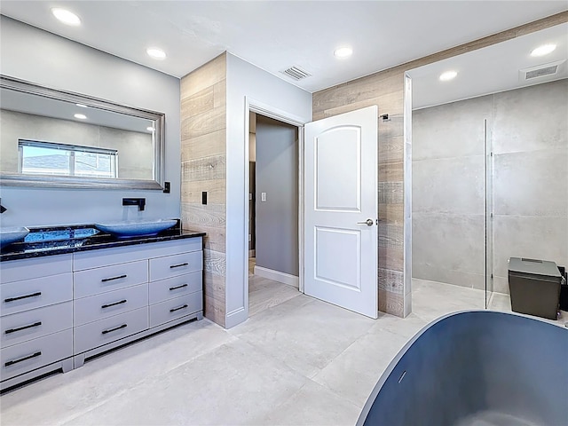 bathroom with recessed lighting, visible vents, and tile walls