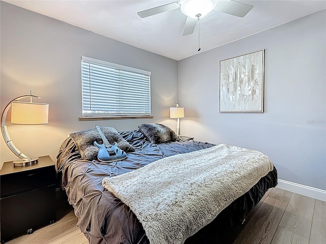 bedroom featuring ceiling fan, wood finished floors, and baseboards