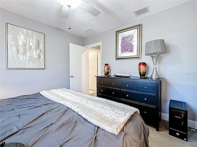 bedroom featuring light wood-type flooring, baseboards, visible vents, and a ceiling fan