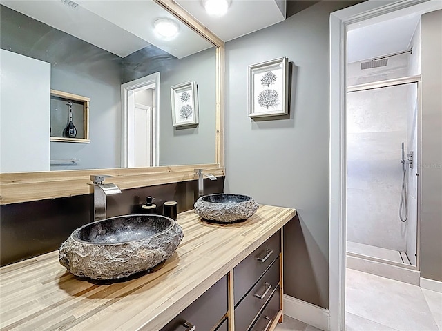 full bath featuring a stall shower, vanity, and baseboards