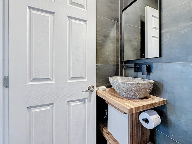 bathroom with backsplash, tile walls, and vanity