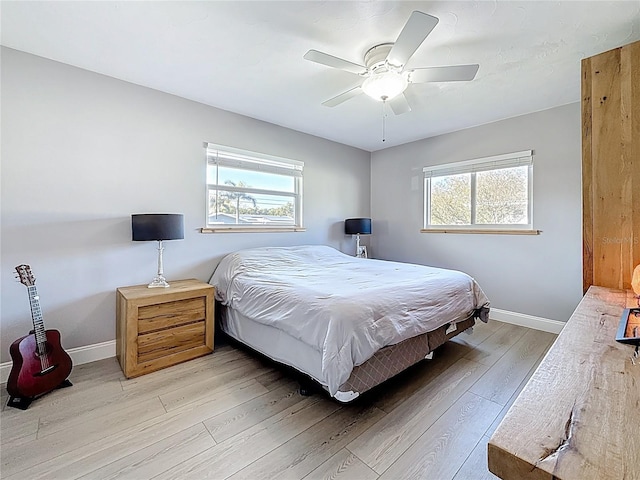 bedroom with light wood-type flooring, ceiling fan, and baseboards