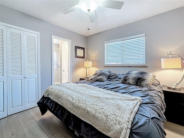 bedroom featuring light wood-style flooring, a ceiling fan, and a closet