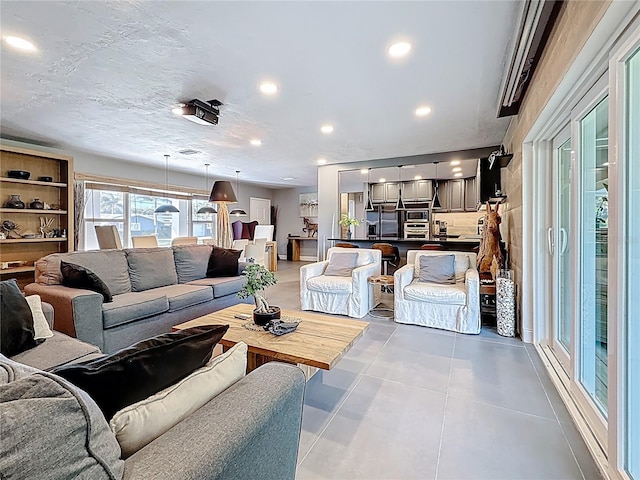 living room featuring recessed lighting, light tile patterned flooring, and a textured ceiling