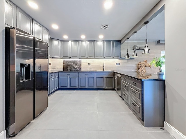 kitchen featuring a sink, visible vents, appliances with stainless steel finishes, backsplash, and dark countertops