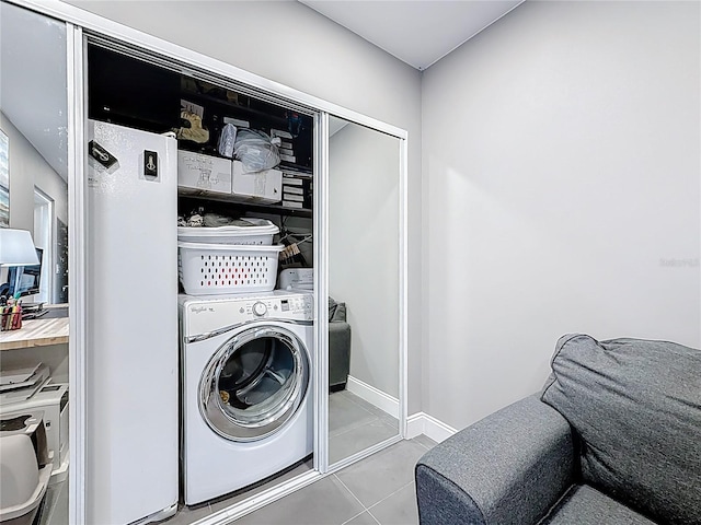 laundry room with laundry area, baseboards, washer / clothes dryer, and tile patterned floors