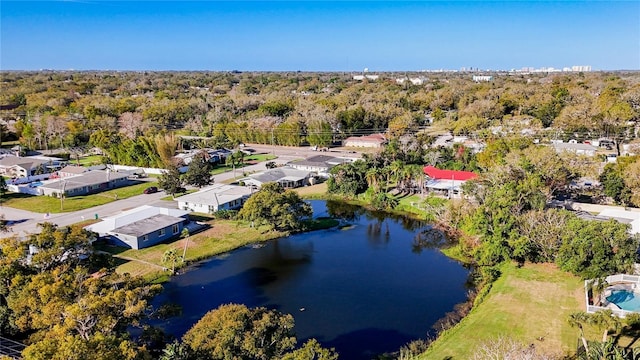 birds eye view of property featuring a water view and a wooded view