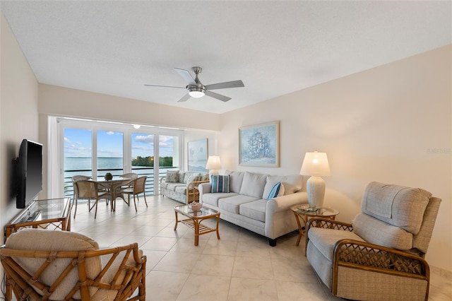 living area with ceiling fan and light tile patterned flooring