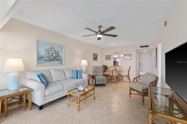 living room with light tile patterned floors, a ceiling fan, and visible vents