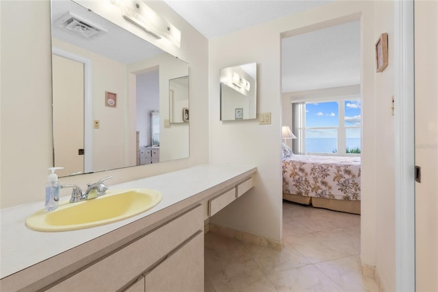 bathroom with visible vents, ensuite bathroom, tile patterned flooring, baseboards, and vanity