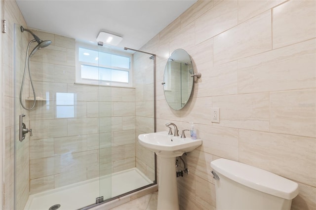 bathroom with a shower stall, toilet, and tile walls