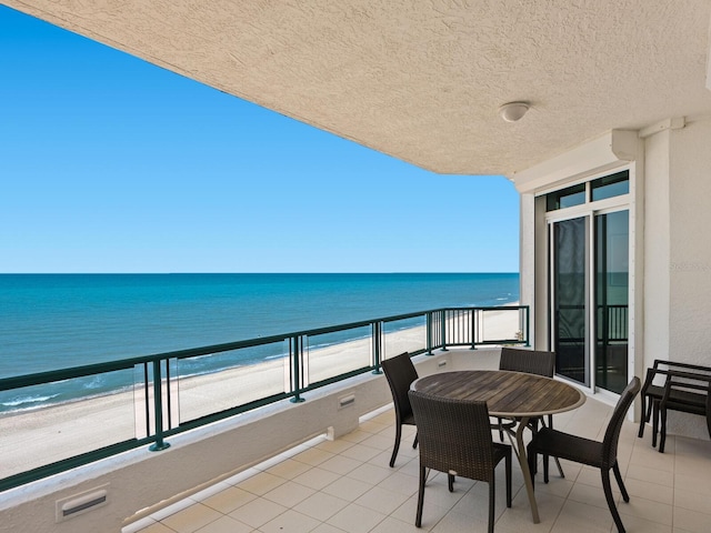 balcony featuring visible vents, a water view, and a beach view