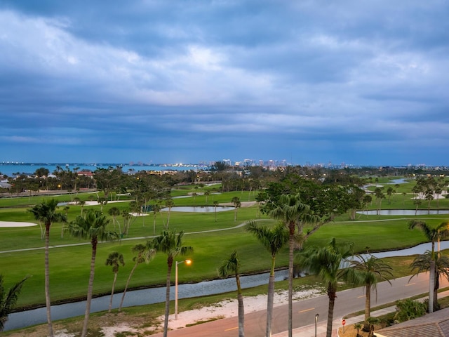 view of property's community featuring a lawn, golf course view, and a water view