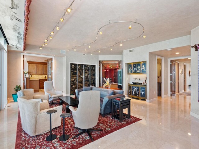 living room with visible vents, rail lighting, and baseboards