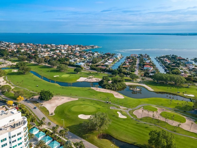 birds eye view of property with golf course view and a water view