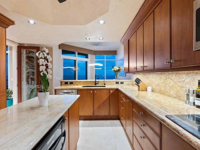 kitchen with decorative backsplash, recessed lighting, brown cabinets, and a sink