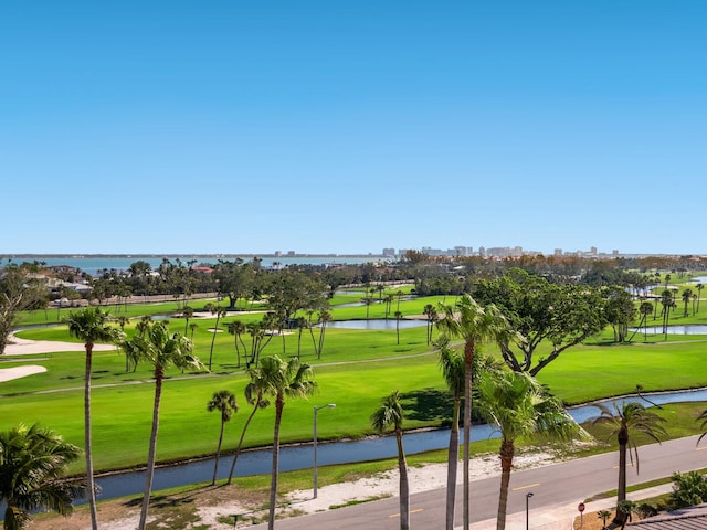 view of community featuring a water view, a lawn, and a city view