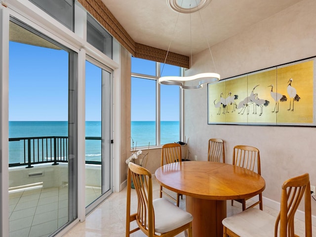 dining space featuring baseboards and a water view