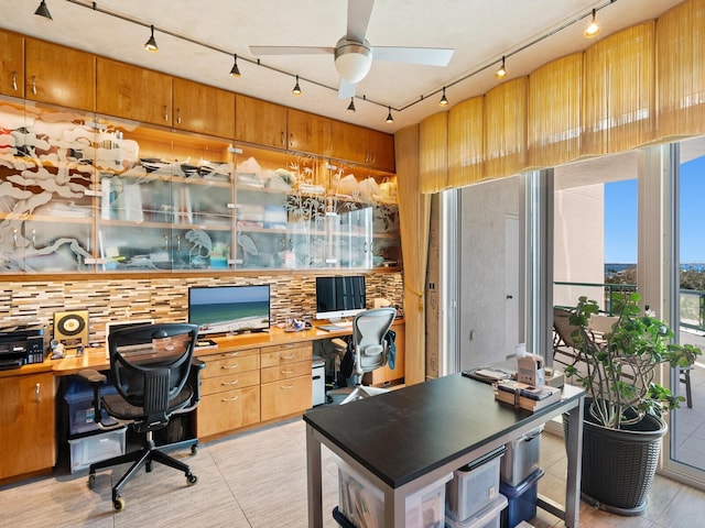 home office featuring light tile patterned floors, built in desk, rail lighting, and a ceiling fan