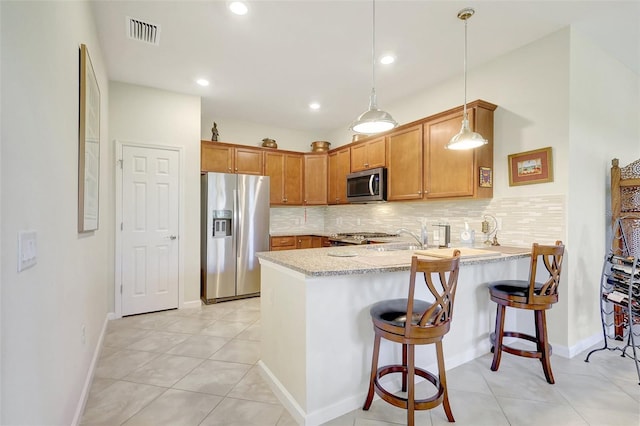 kitchen featuring stainless steel appliances, backsplash, visible vents, and a peninsula