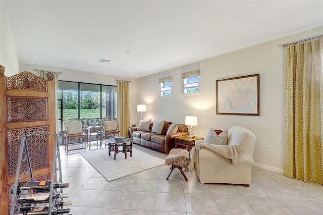 living room featuring light tile patterned flooring, visible vents, and baseboards