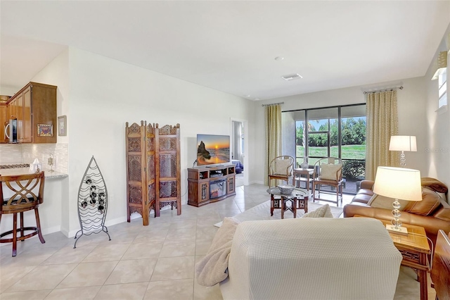 living area with light tile patterned floors, baseboards, and visible vents