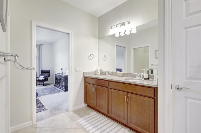 full bathroom featuring baseboards, double vanity, a sink, and tile patterned floors