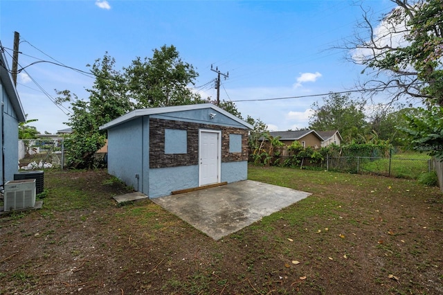 view of outdoor structure with an outdoor structure, cooling unit, and a fenced backyard