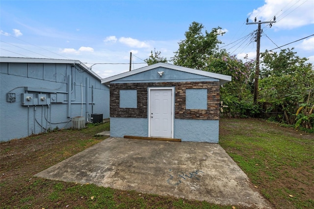 view of outdoor structure featuring an outbuilding, central AC unit, and fence