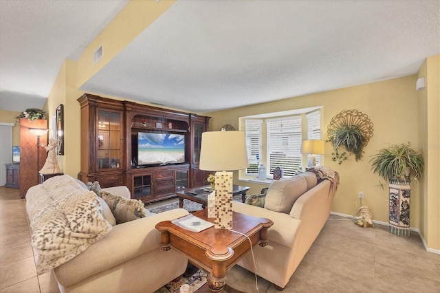 5614 Garden Lakes Dr, Bradenton, FL 34203 - living area featuring tile patterned flooring, visible vents, a textured ceiling, and baseboards